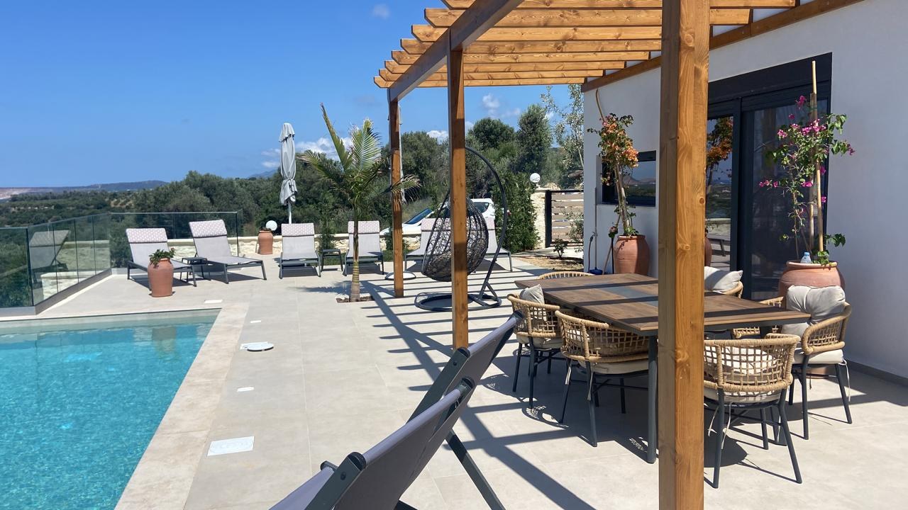 Completed villa terrace with a pool and shaded dining area